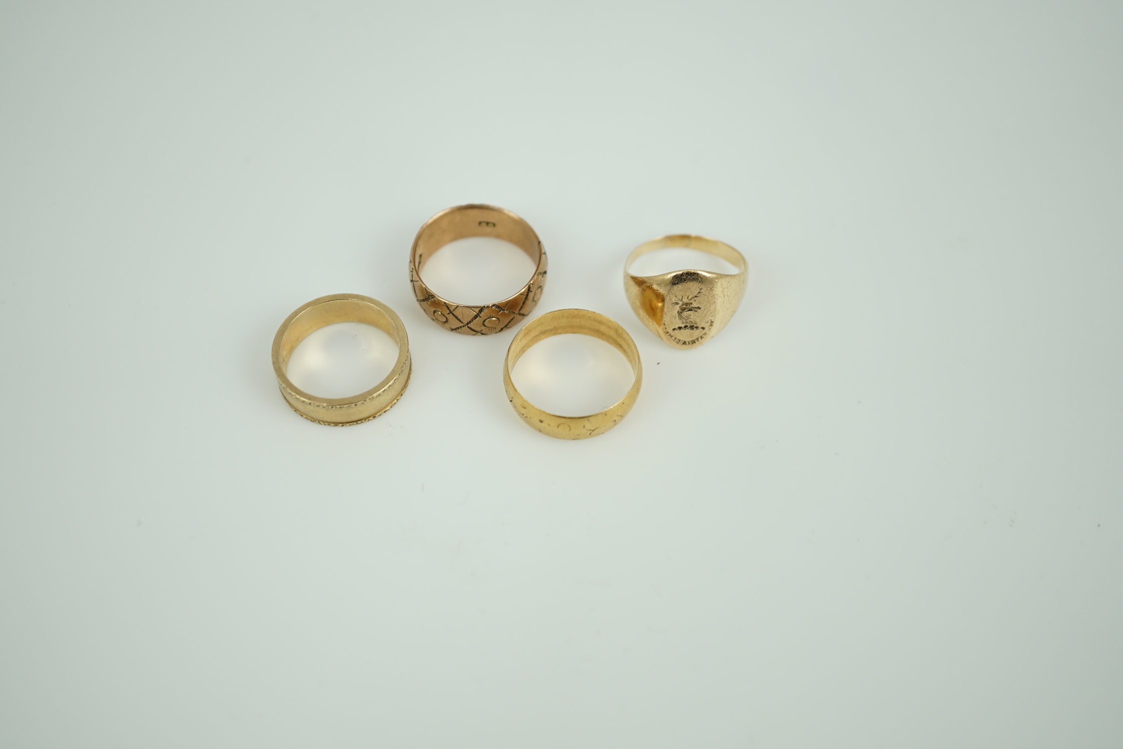 An 18ct gold wedding band, 4.3 grams, two 9ct gold wedding bands, 10 grams and a 14k intaglio signet ring, 3.9 grams.